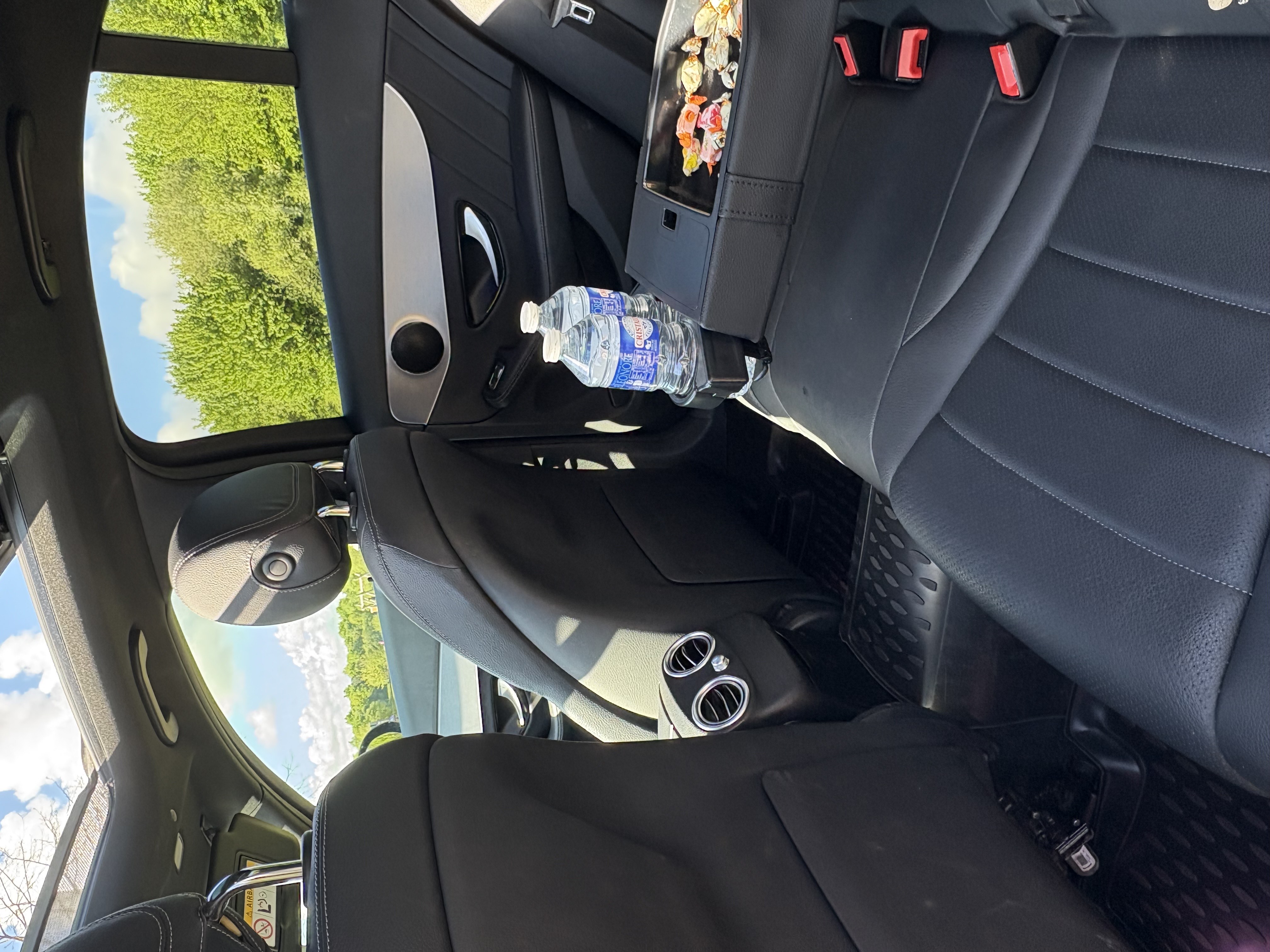 Voiture VTC haut de gamme avec chauffeur privé en costard ouvrant la porte à un client à Rennes.