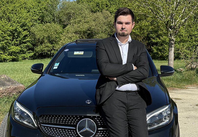 Voiture VTC haut de gamme avec chauffeur privé en costard ouvrant la porte à un client à Rennes.